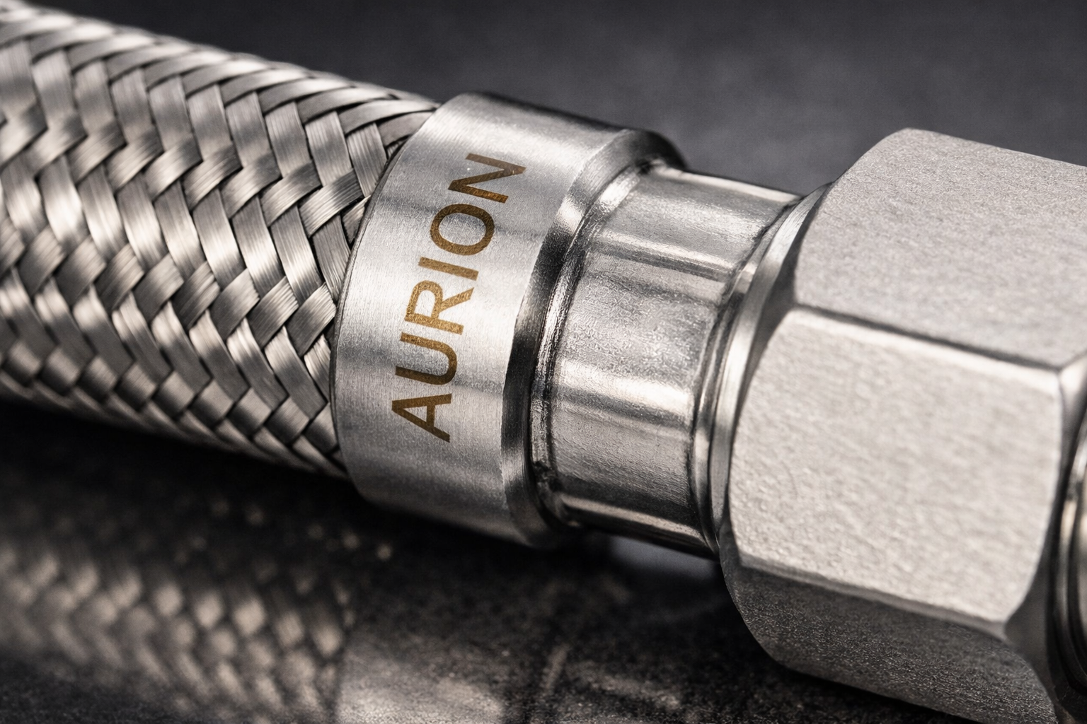 Detalhe premium AURION em aço inox sob revelação.